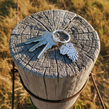 Load image into Gallery viewer, Keys with a camel keychain on a wooden post in a grassy field