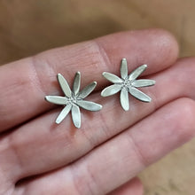 Load image into Gallery viewer, Flannel Flower Studs Modelled between Jemica's finger tips close up view