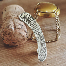 Load image into Gallery viewer, HER ear cuff up close leaning on a champagne cork and the champagne bottle cover