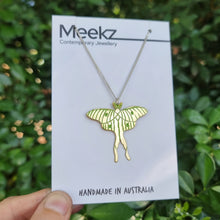 Load image into Gallery viewer, Luna moth necklace hanging on a packaging card