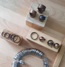 Load image into Gallery viewer, Copper Tube Rings on display with a ring sizer