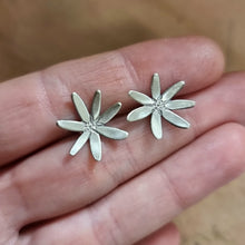 Load image into Gallery viewer, Flannel Flower Studs Modelled between Jemica&#39;s finger tips close up view
