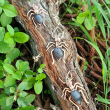 Load image into Gallery viewer, Meat‑ant–inspired earrings made from black car vinyl with recycled copper bodies, sterling‑silver hooks, and hypoallergenic stainless‑steel jump rings, arranged on textured wood surrounded by green foliage.
