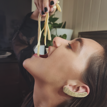 Load image into Gallery viewer, FEED ME ear cuff modelled by Sheridan Eveline eating pasta
