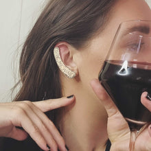 Load image into Gallery viewer, GIVE ME WINE ear cuff modelled by Sheridan Eveline holding her red wine and pointing to the cuff
