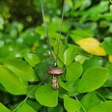 Load image into Gallery viewer, Button Mushroom Necklace Hanging above a bush
