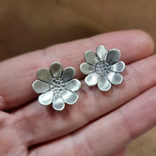 Load image into Gallery viewer, Paper Daisy Studs modelled sitting between Jemica&#39;s fingers on her hand for size comparison

