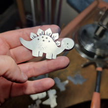Load image into Gallery viewer, Stegosaurus on Jemica&#39;s hand in the studio while making them

