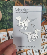 Load image into Gallery viewer, Packaging Card with Velociraptor dinosaur-shaped earrings labeled &#39;Meekz&#39; and &#39;Handmade in Australia&#39;.
