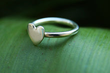 Load image into Gallery viewer, A sterling silver heart ring photographed on a leaf
