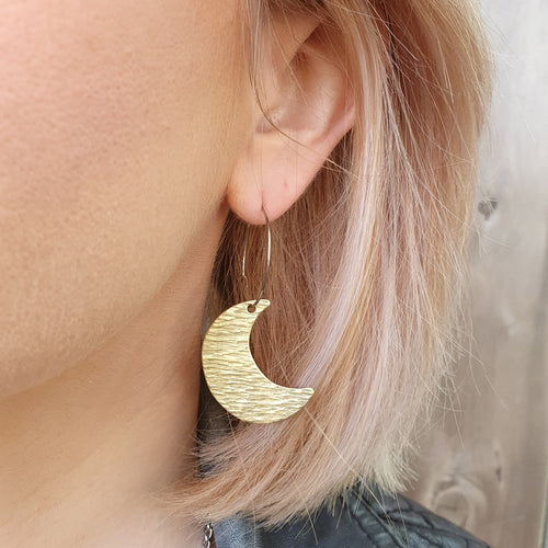Crescent moon hoop earrings on model close up